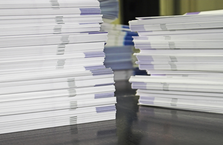 Spine view of stacks of printed brochures on a glossy table